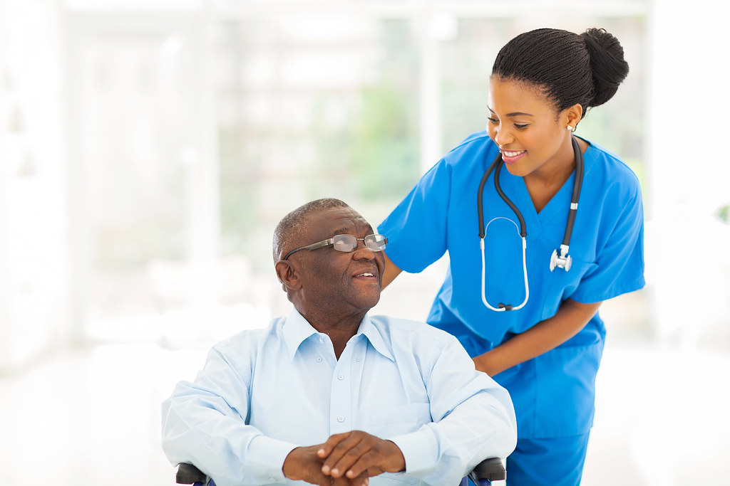 African American caregiver assisting a senior resident in a wheelchair